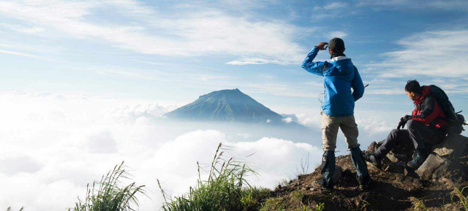 two people looking at a mountain to conquer next